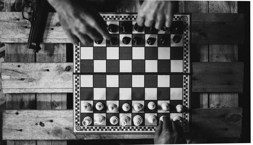 black and white image of checkers with people moving them on