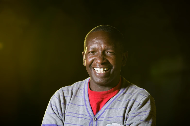 a man smiles with his arms crossed