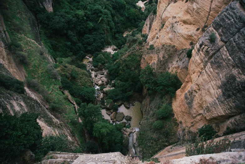 a person walks up a rock outcropping in a mountainous area