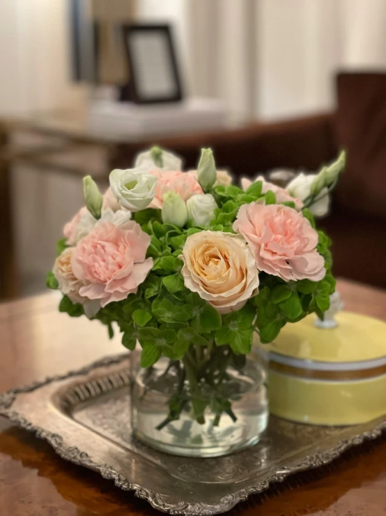 a vase with flowers sitting on top of a wooden table