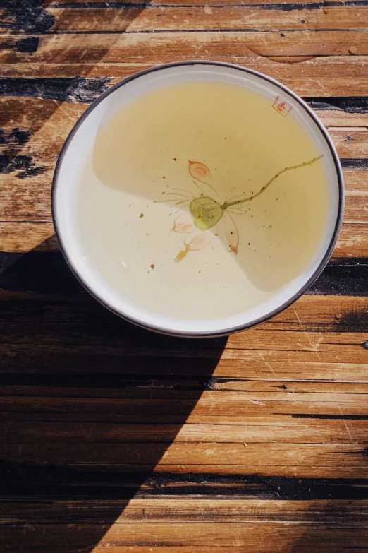 a cup of tea with a flower stuck in it