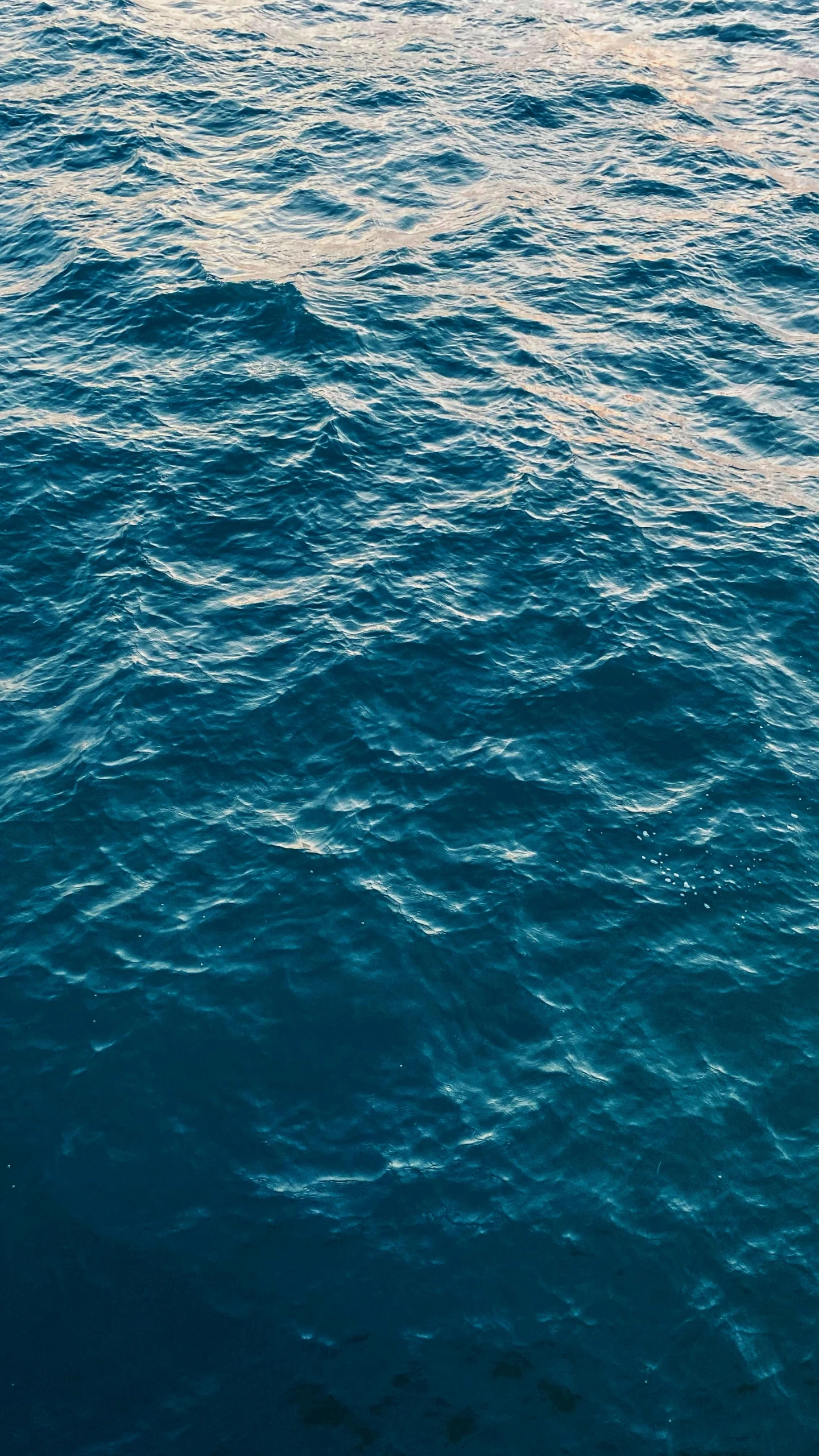 some blue water and a yellow buoy in the distance