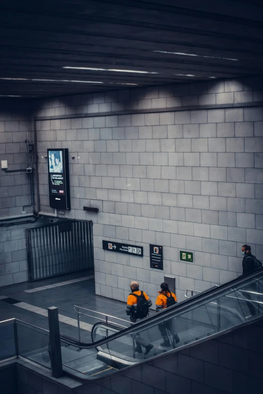 two men riding up an escalator in a building