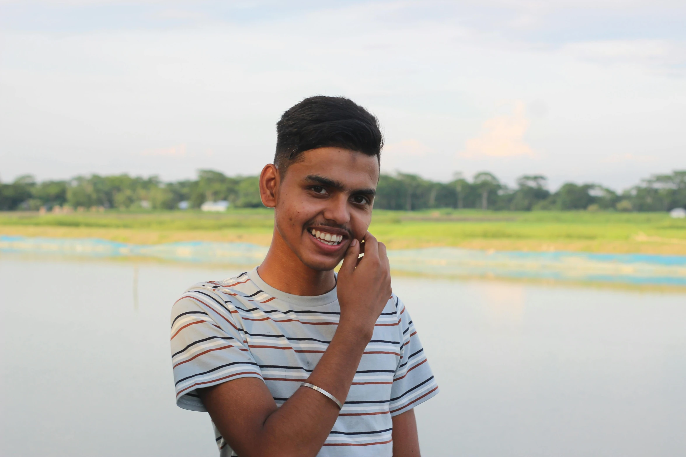 a young man is smiling while talking on the phone