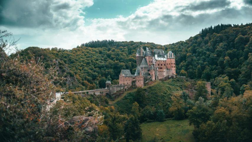 an old building surrounded by wooded area with mountains