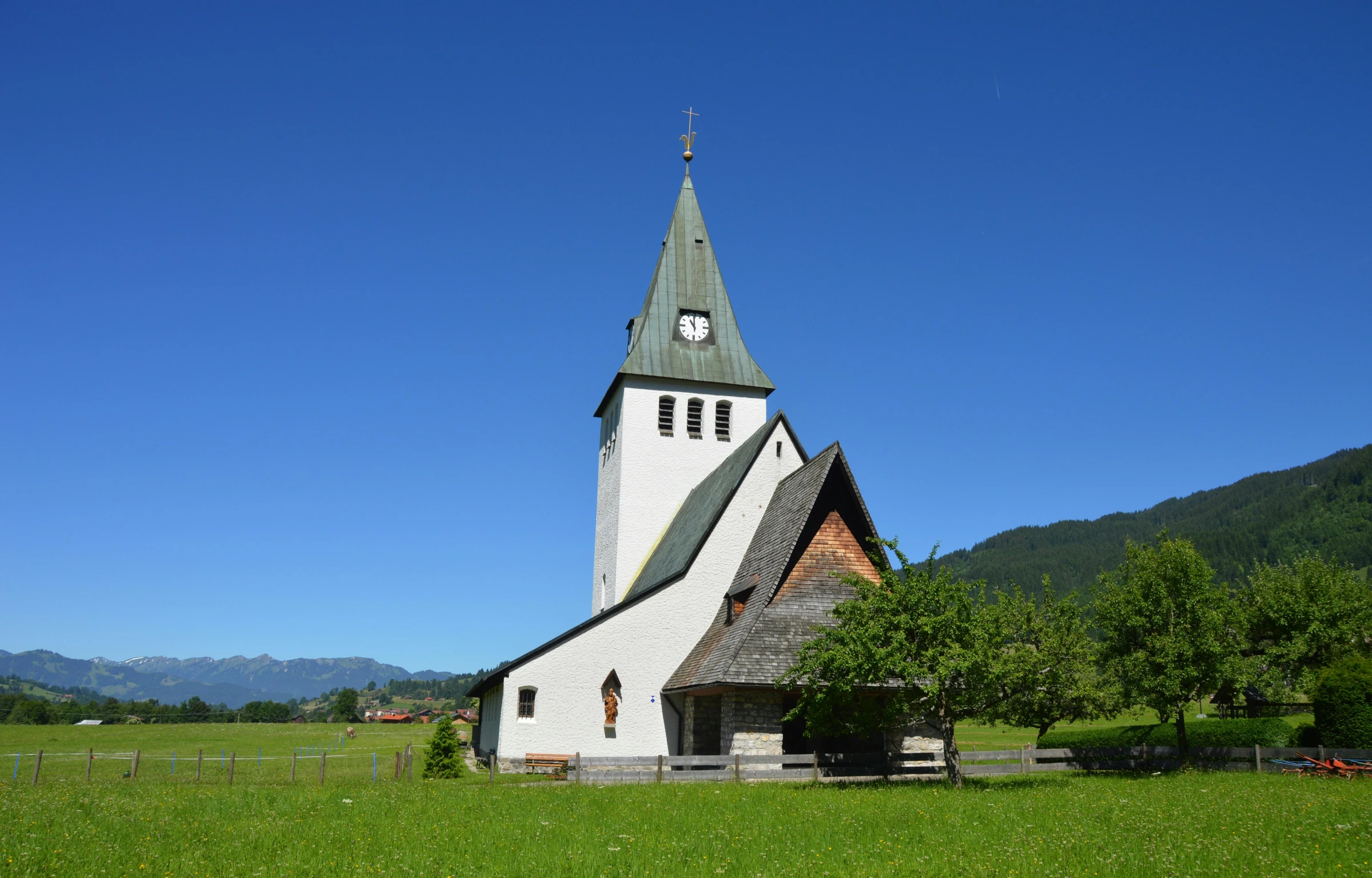 a white and black church sits on some green grass