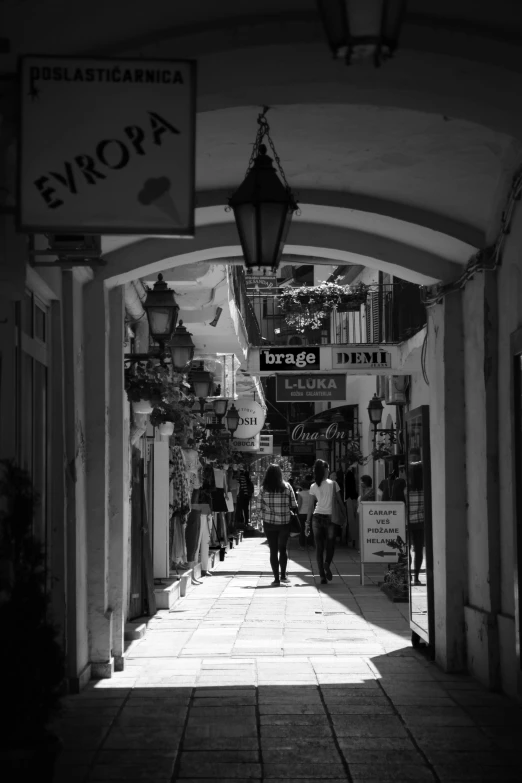 two people walking down a walkway between buildings