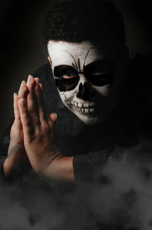 a man in a skeleton mask holding his hands together