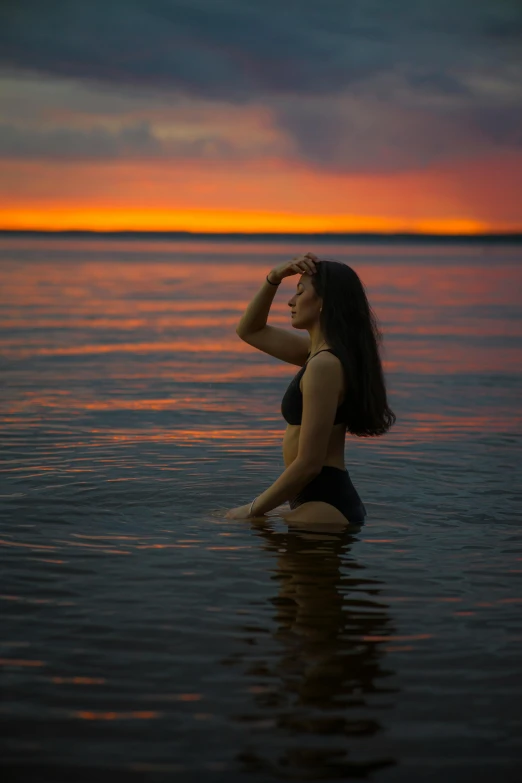 a woman in her bikini is sitting on the water