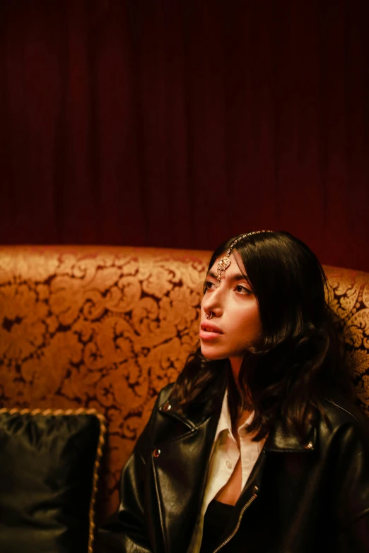 woman in leather jacket and beaded headband posing for a portrait