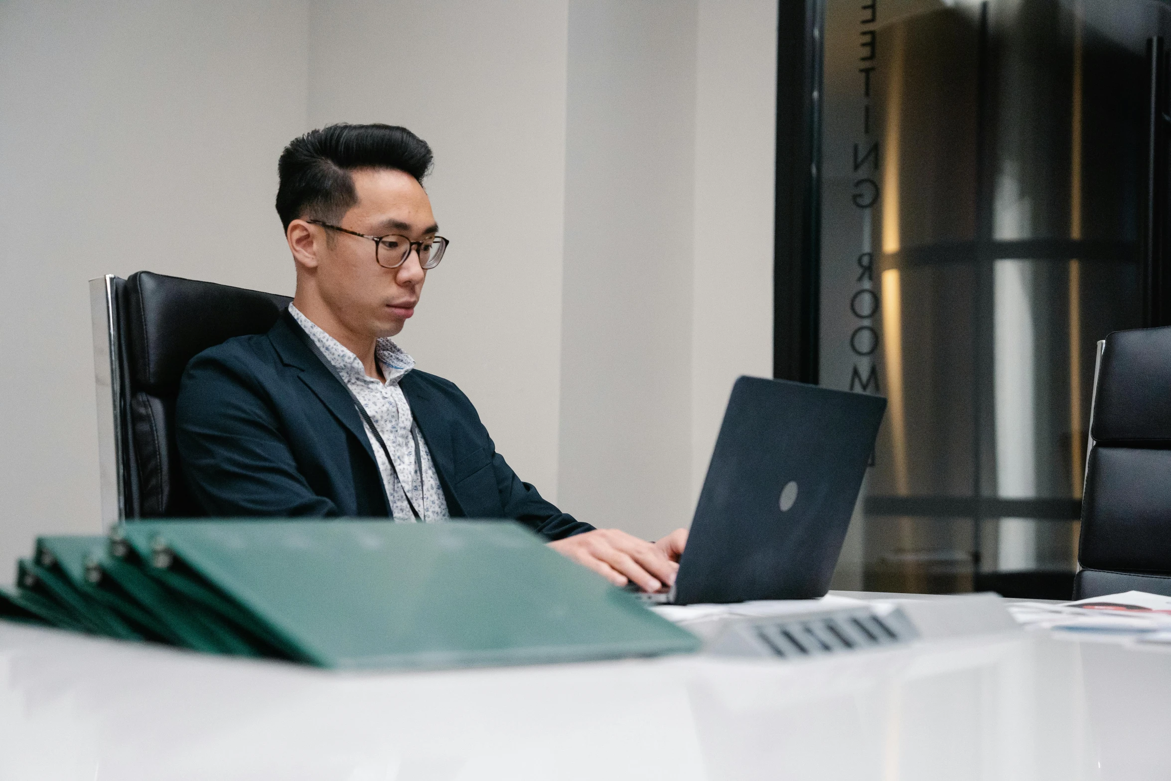 a man is sitting in front of his laptop computer