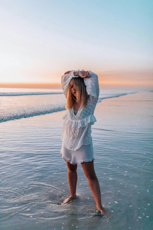 a young woman in a white dress on a beach