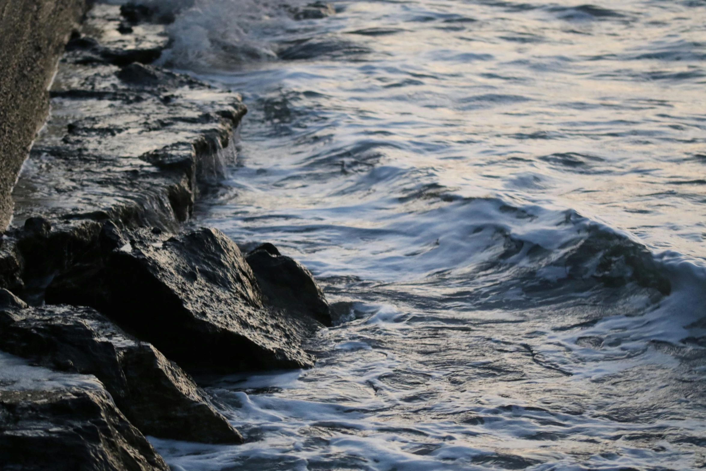 a close up s of the water next to rocks
