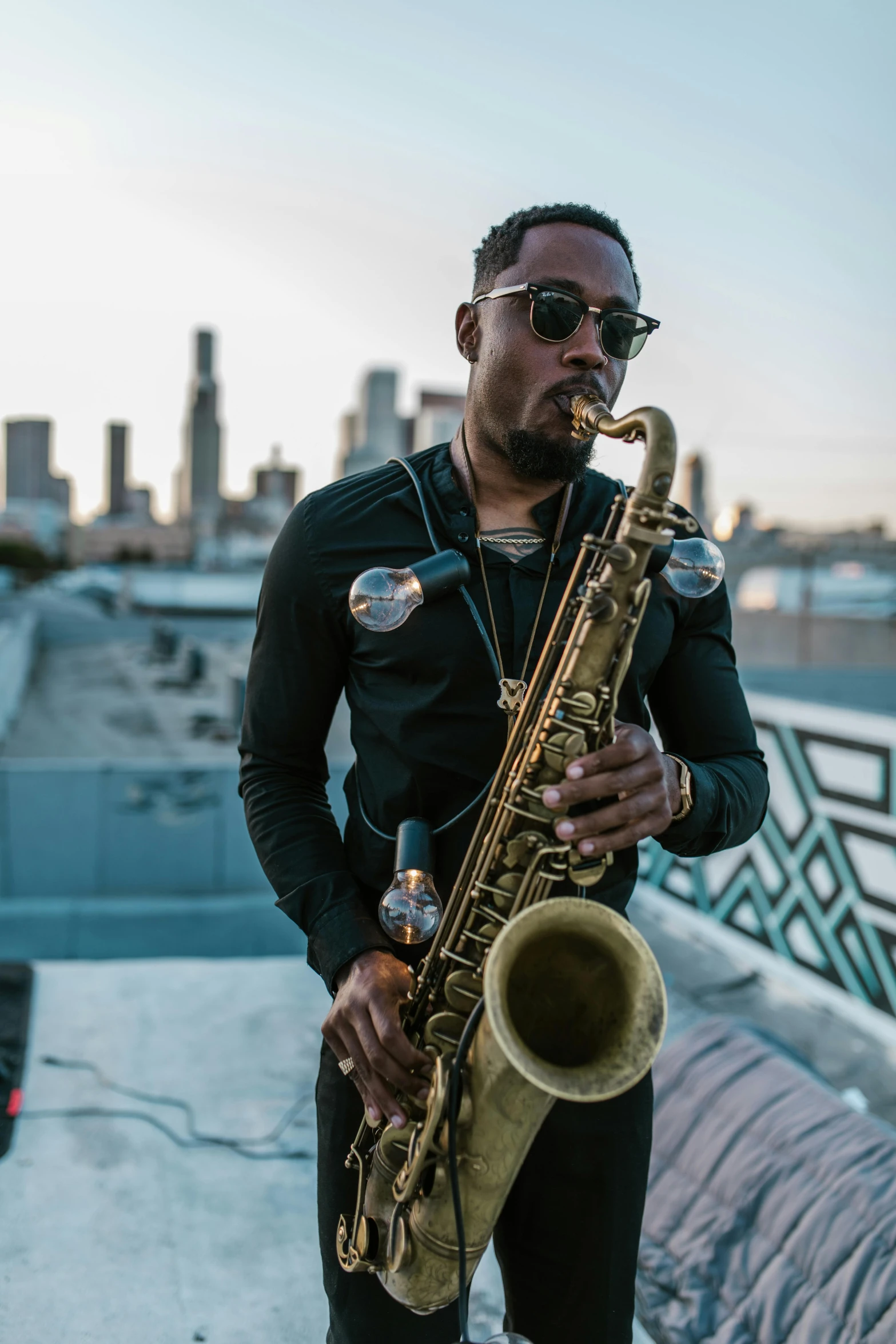 a man holding a saxophone standing on top of a roof