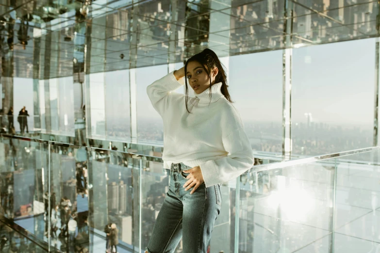 the young lady is posing for a po in front of a glass wall