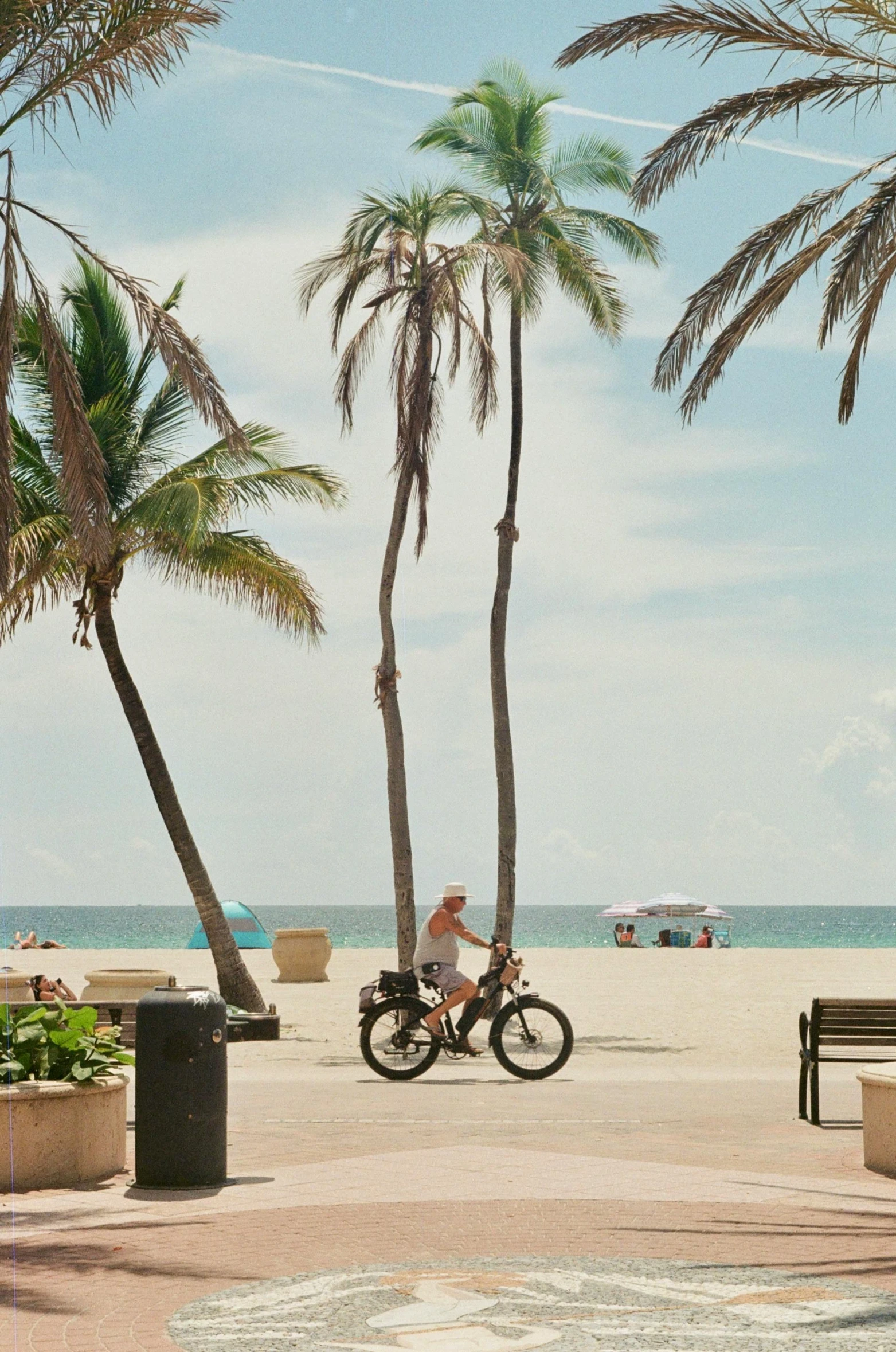 a person riding a bike along the beach