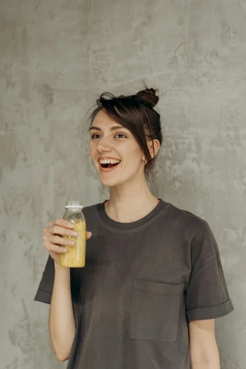a girl drinking a glass of juice smiles