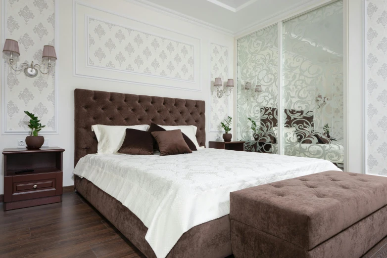 a large brown bed in a white walled bedroom