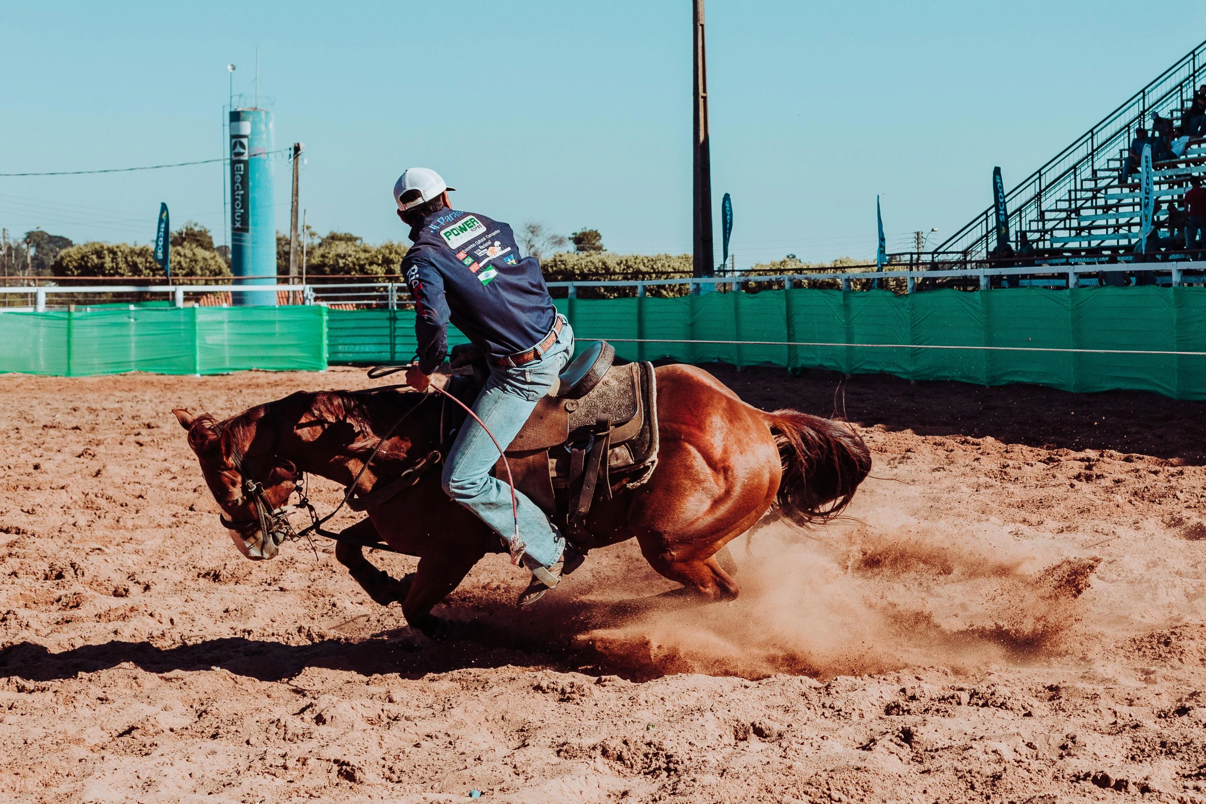 a man rides his horse in a dirt arena