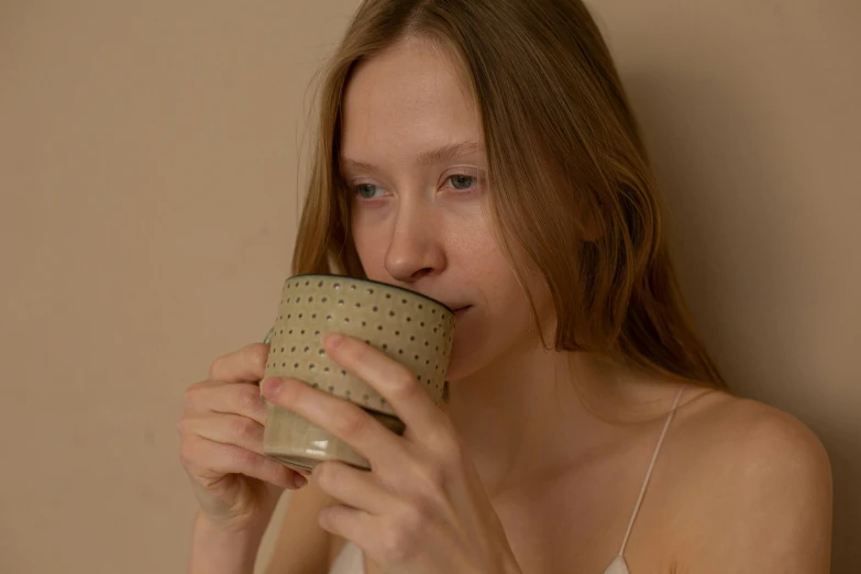 a woman drinking out of a coffee mug
