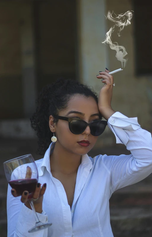 a young woman smoking a cigarette and drinking wine