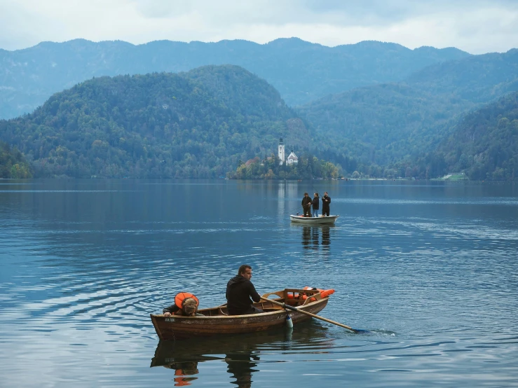 two boats on a body of water with several people