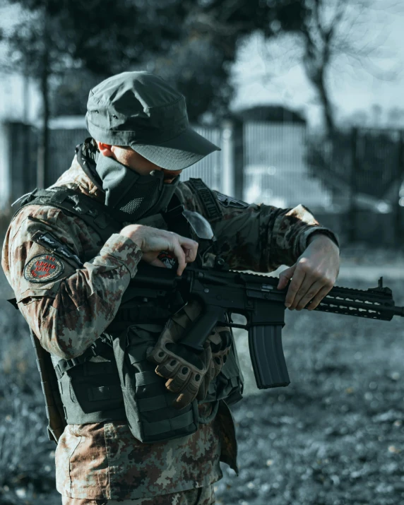 a man with a mask on holding an automatic rifle