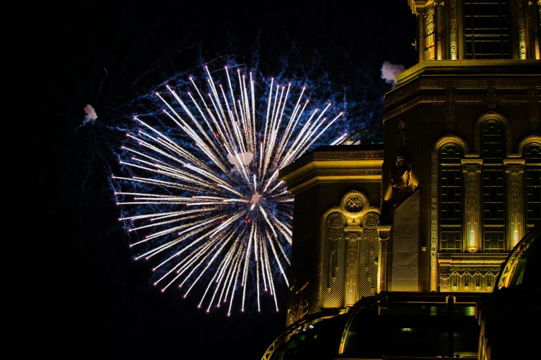 a firework displays in the dark on the side of a building