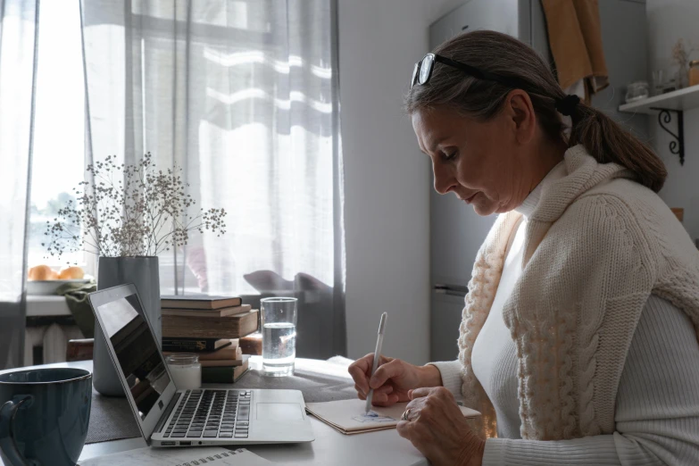 a woman at her desk writing on a piece of paper