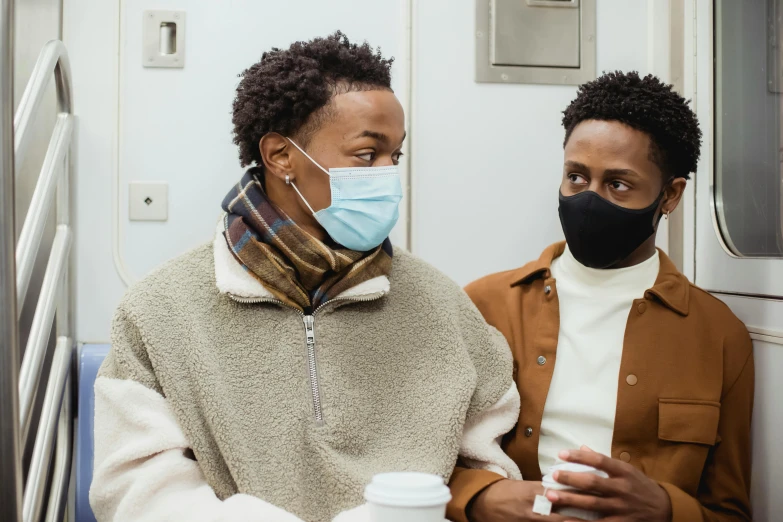 two people on the train wearing masks