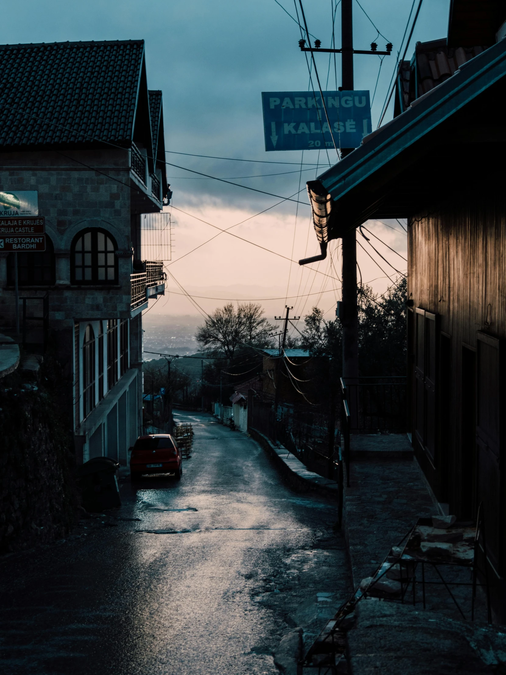 an empty street with some rain and a car