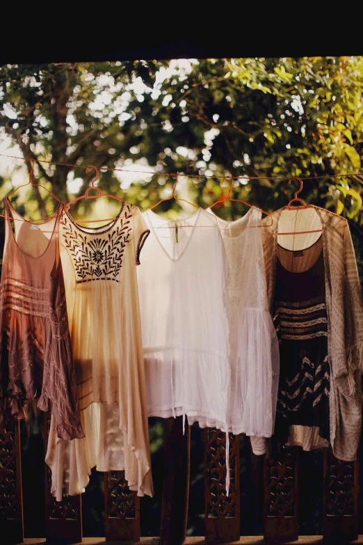 an array of blouses hanging from a clothes line