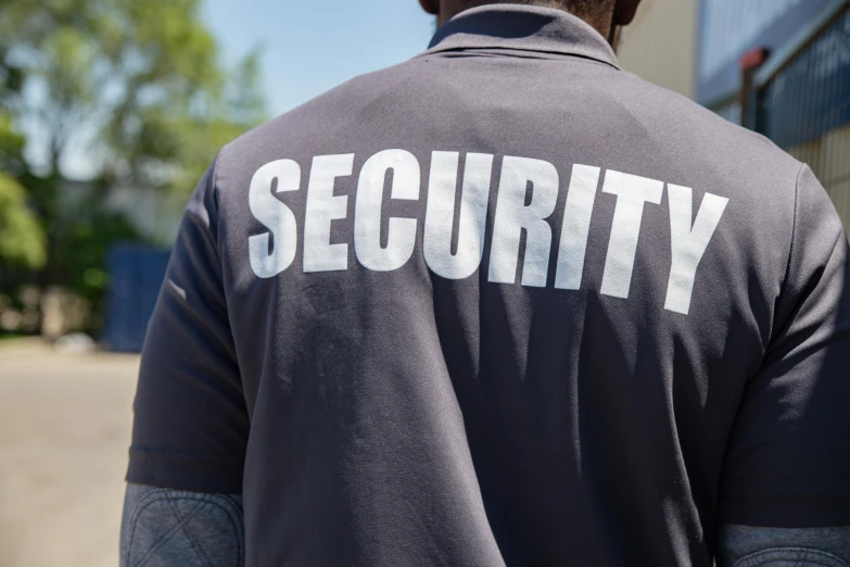 there is a security man walking outside wearing a t - shirt