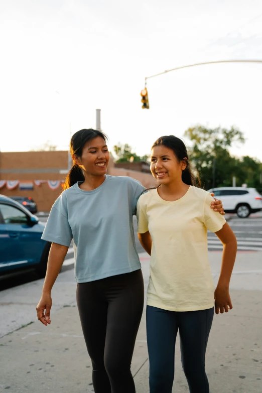 two smiling s are walking down the street