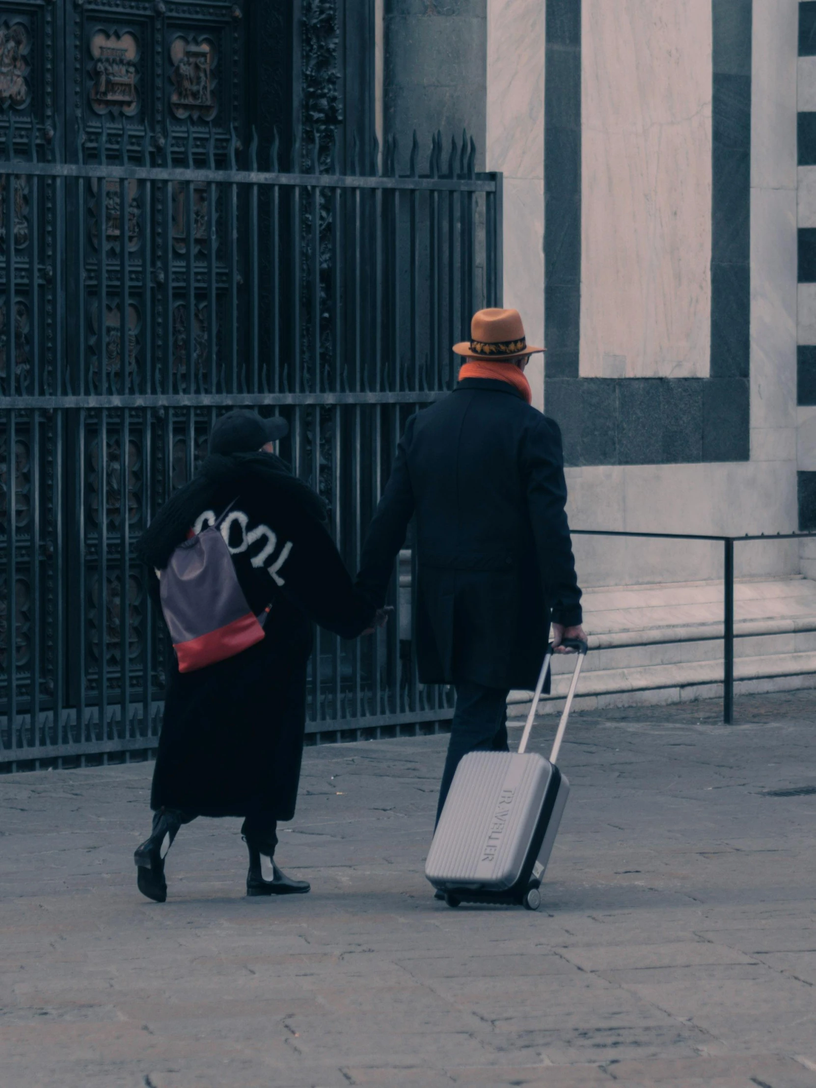 a woman and a man are walking with suitcases