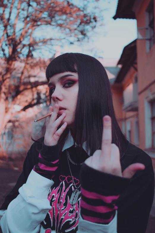 a young woman smoking and making a peace sign with her hand