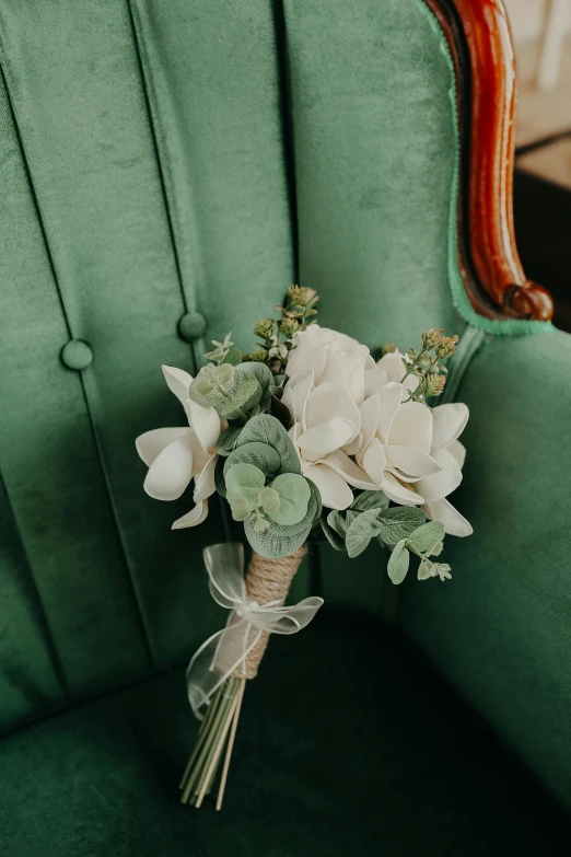 a bouquet is wrapped in the back of a green chair