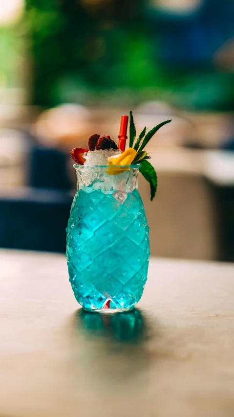 a blue glass filled with fruit and ice