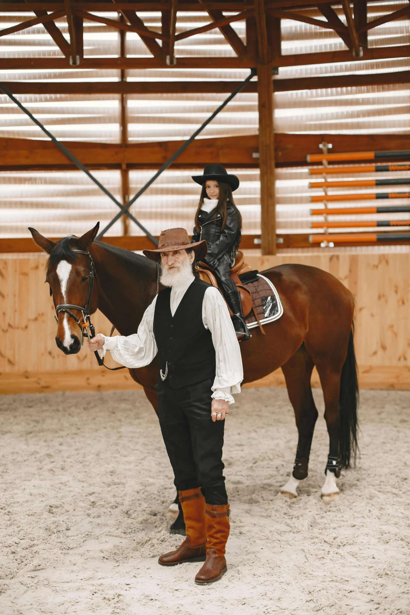 a man in a hat is standing next to a horse