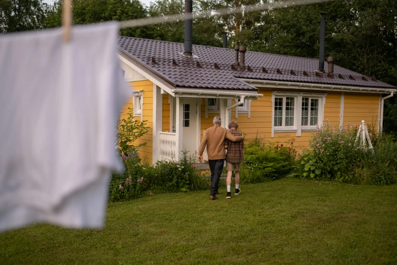 two people walk in front of the house