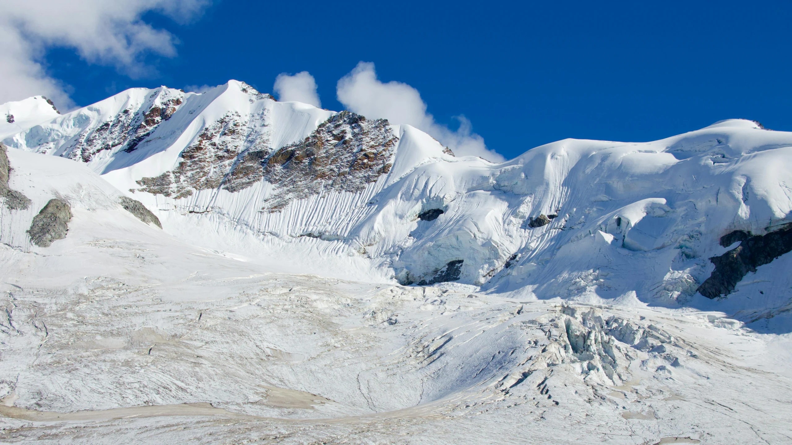 a snow covered mountains with blue skies above