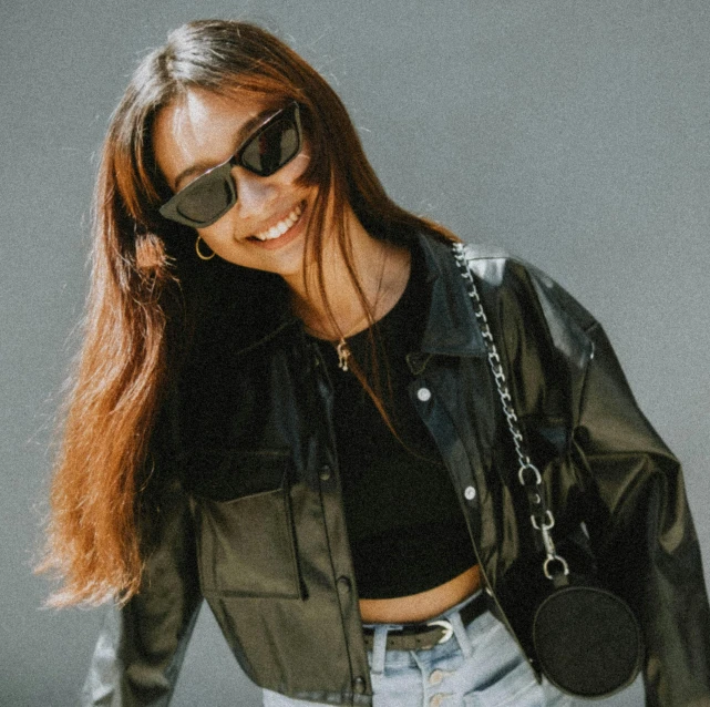 a young woman wearing sunglasses posing for a po