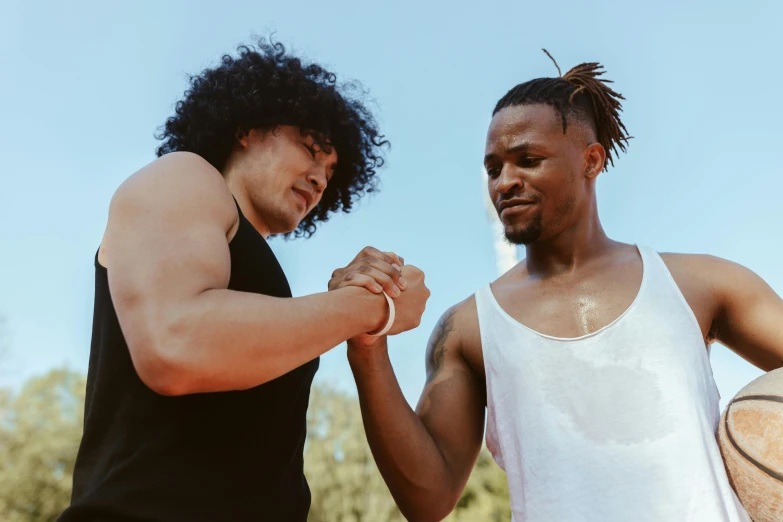 two young men holding hands, one on the other