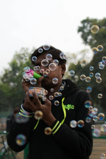 there is a man that is blowing bubbles on his hand