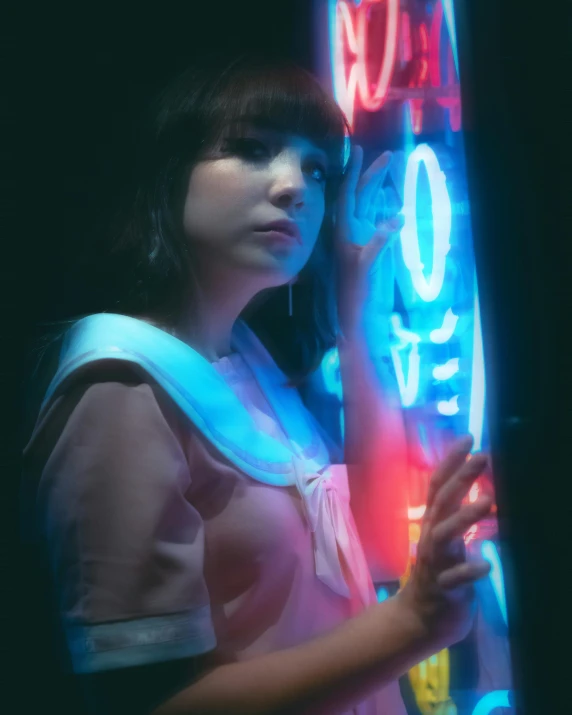 the girl is leaning on the neon sign