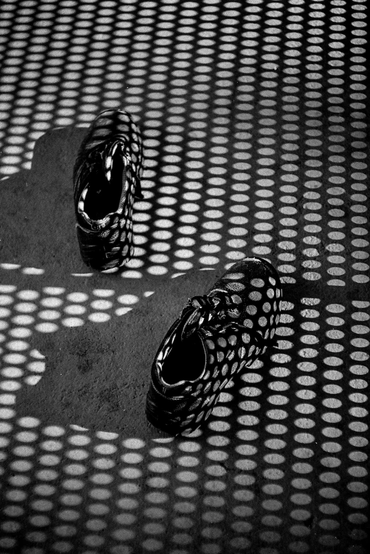 two shoes sitting on a carpet that's covered with dots