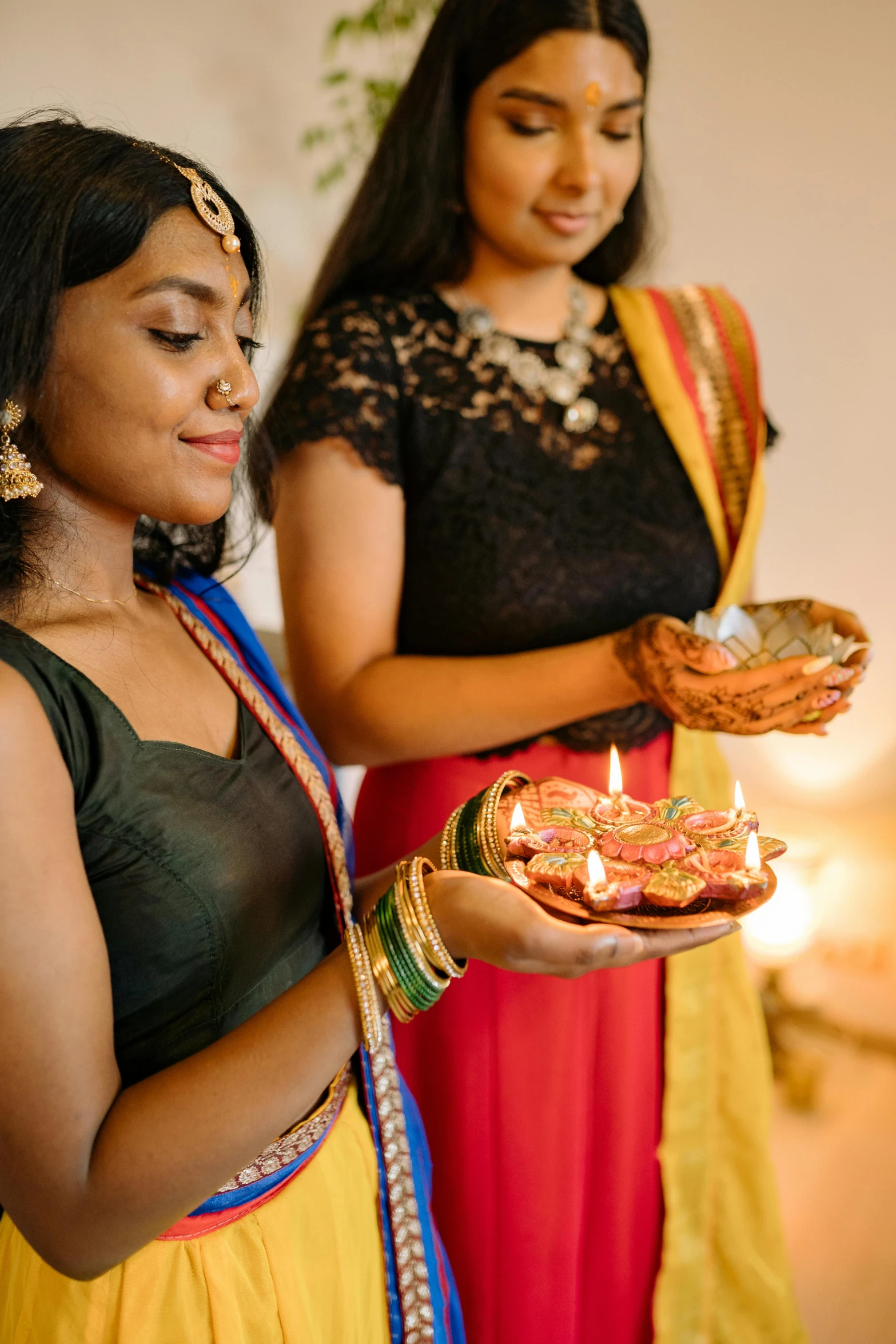 a young indian woman is holding a small plate of food