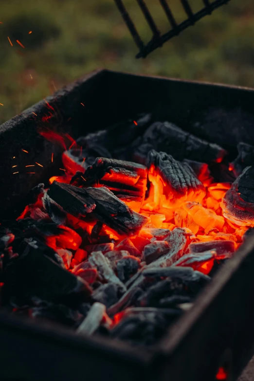 the wood is burning with bright flames and black charcoal