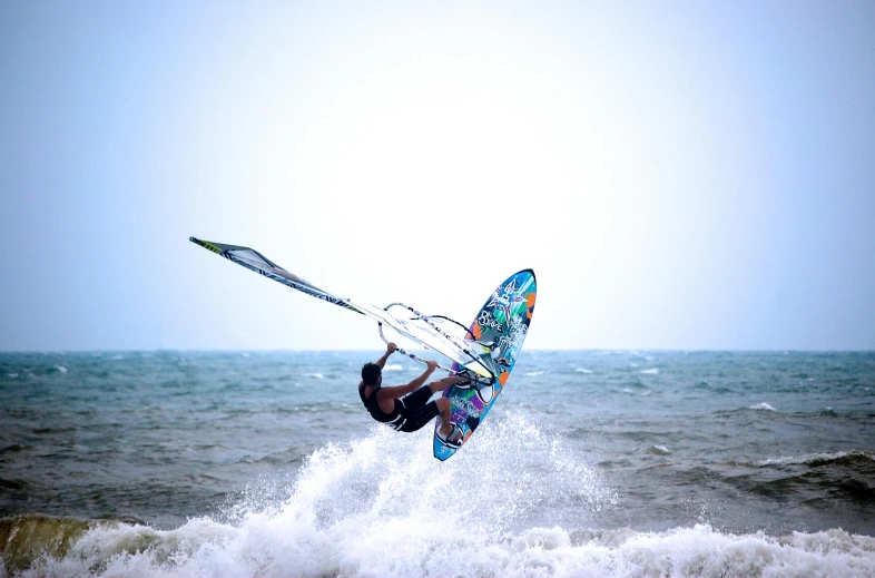 a man riding on top of a wave on top of water