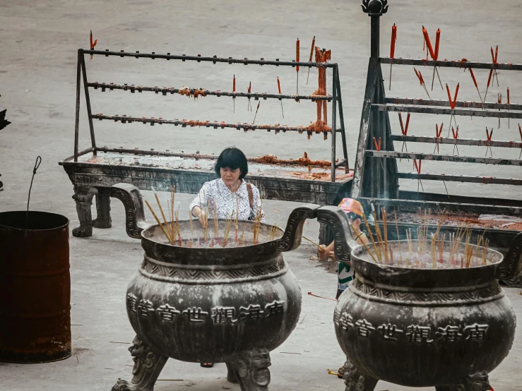 an oriental style woman sitting between two large vases